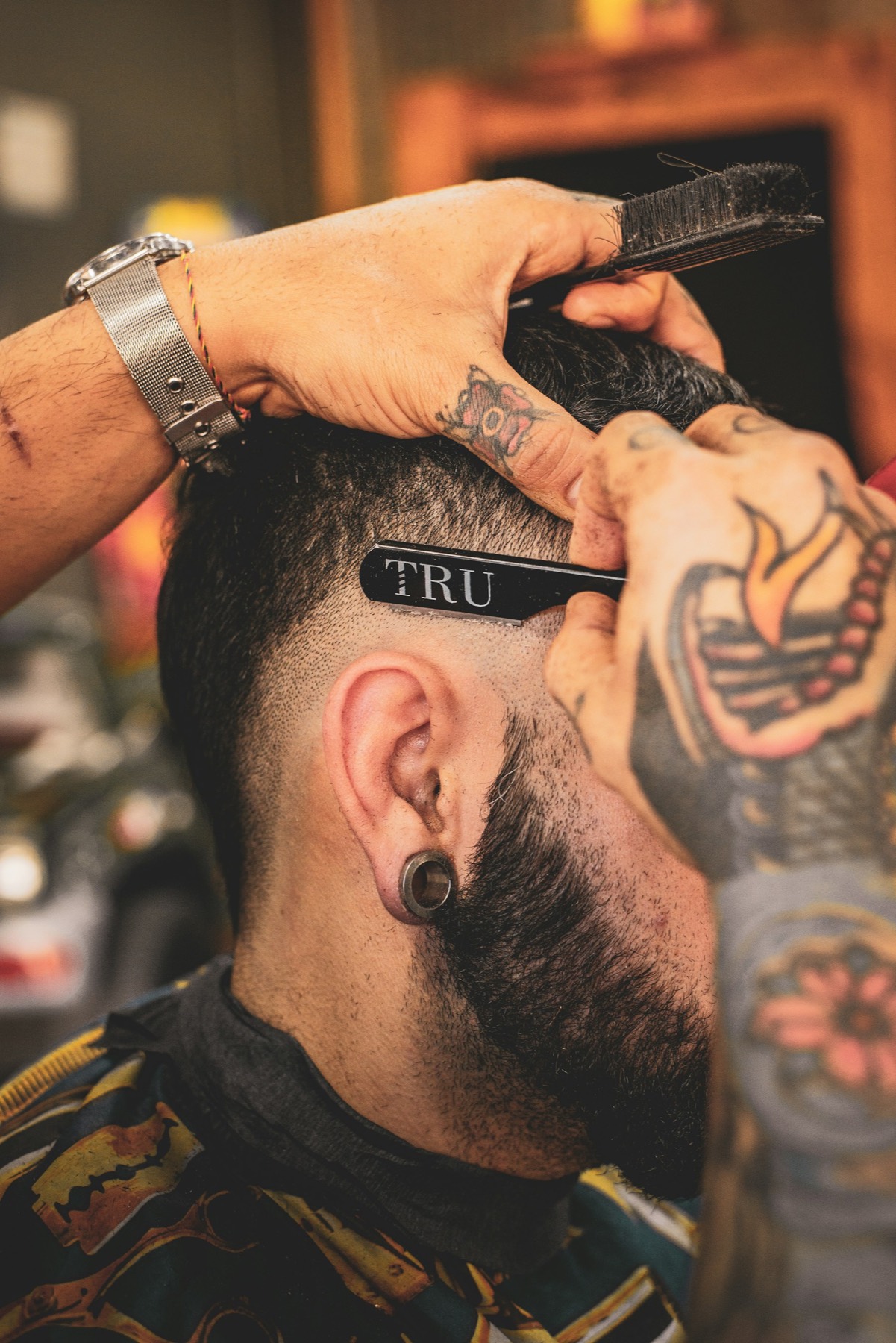 Barbier en action sur un client, machine en main